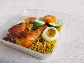 Nasi Biryani or Biryani Rice with honey roasted chicken on a plastic container