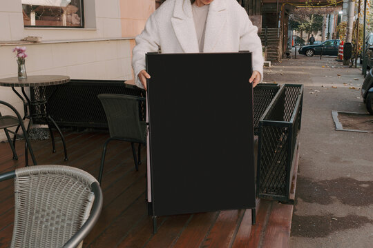 Cafe owner preparing to update the outdoor menu sign