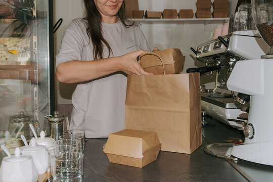 Owner prepares takeout orders at a small cafe during busy hours