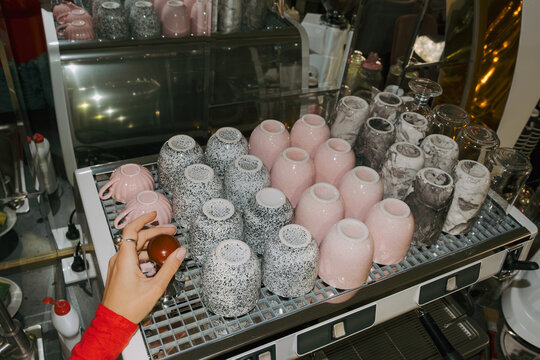 Coffee shop owner prepares unique cups for customers in cafe