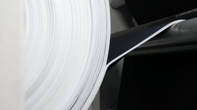 Close up of a roll of textile being unrolled opened with cloth being pulled away