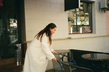 Cafe owner arranging outdoor seating in bustling neighborhood