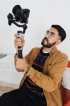 Photographer using both hands to hold a stabilizer with a camera.