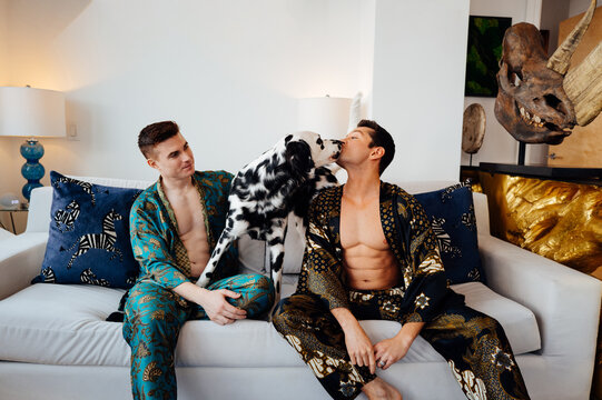 Stylish Gay Couple playing in a Modern apartment with Dalmatian Dog
