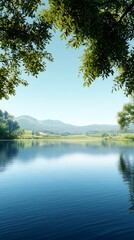 Obraz premium Clear blue water reflects distant green hills under a canopy of vibrant green foliage