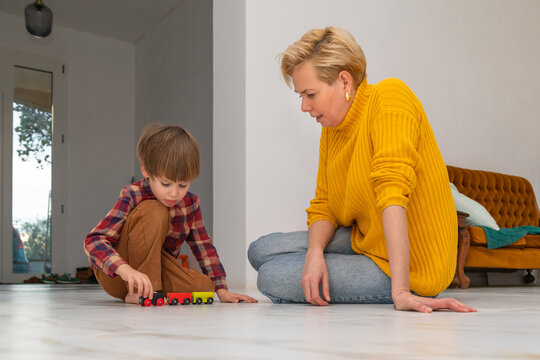 Autistic child playing with toy train with mother&rsquo;s support