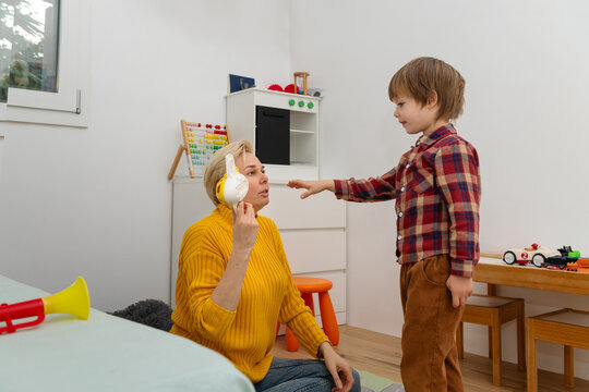 Mother and autistic child tidy toys