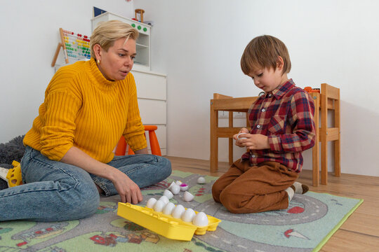 Mom and her autistic child playing with Montessori egg sorter
