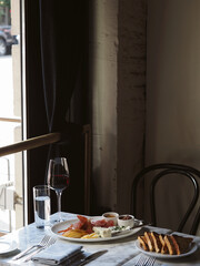 Wine Glass by Restaurant Window in Moody Ambiance © Maria Ponomaryova