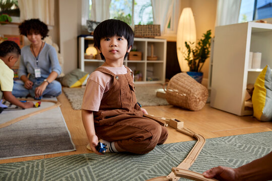 Boy playing with toy train in daycare