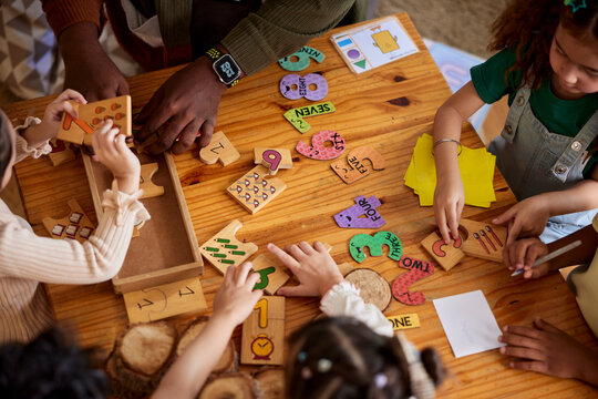 Diverse students learning math with numbers in preschool. 