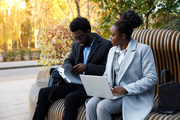 Legal consultant providing services to client on bench in park 