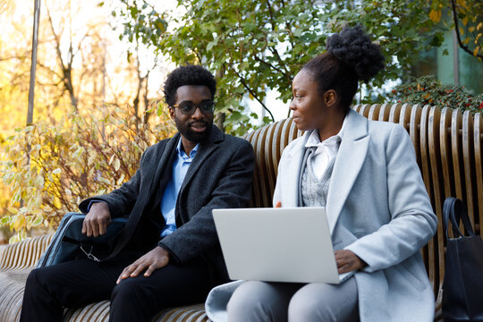 Startup founders discussing business venture on bench in park