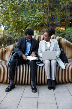 Bookkeeper demonstrating accounting review to entrepreneur on bench 