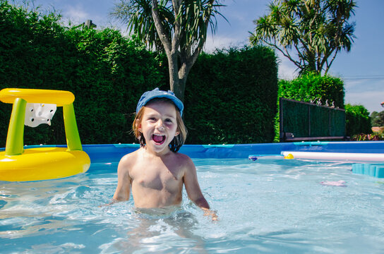 Happy child playing in a swimming pool during summer vacation