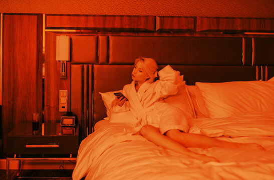 young woman  with cell phone on the bed