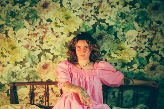 Young Woman in a Pink Dress on the Bed