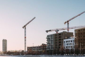 Construction Cranes Above Modern Buildings