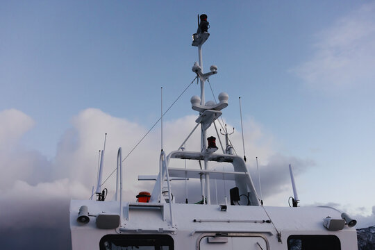 Boat radar and antenna equipment against cloudy sky