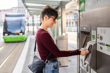Woman paying for public transport ticket at automatic machine