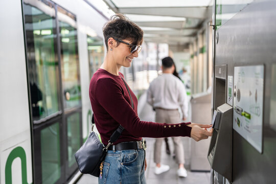 Woman validating her tram ticket at the station in Bilbao, Spain