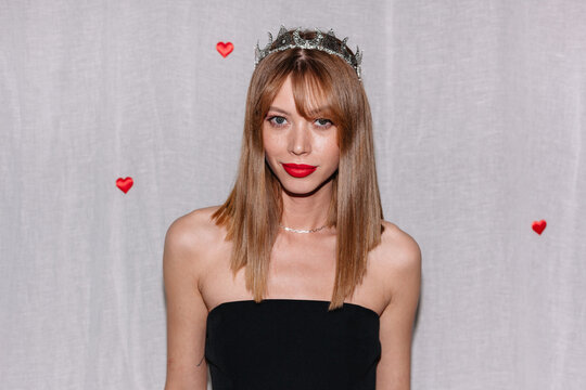 Elegant young woman in a black dress wearing a tiara