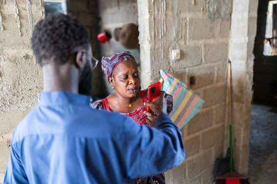 Senegalese man showing smartphone to woman in africa