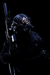 Special forces soldier equipped with advanced tactical gear in low light setting