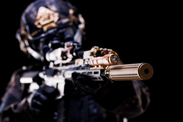 Close-up of a tactical rifle with advanced attachments on a black background