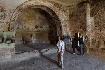 A young woman stands in the hall of an ancient church