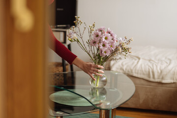 Woman putting the flowers on the table