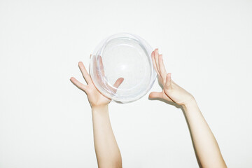 Hand holding clear geometric plastic rounded bubble with flash