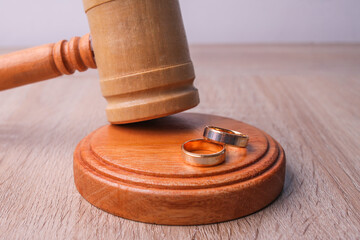 Wooden judge gavel and golden rings, divorce concept.