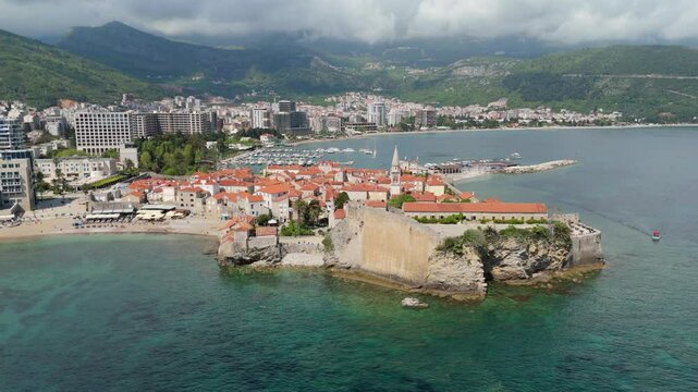 Aerial droen view Budva old town Stari harbour yachts Medieval Dubrovnik blue waters riviera mountains vacation holiday coastal Adriatic Mediterranean 
