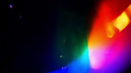 A dark background with a rainbow spectrum of glowing light flares transitioning in various colors creating an abstract visual effect used in editing or visual design - Powered by Adobe