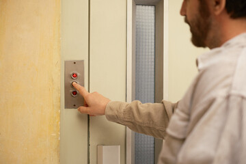 Crop of anonymous pressing elevator button