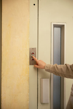 Anonymous hand pressing elevator button