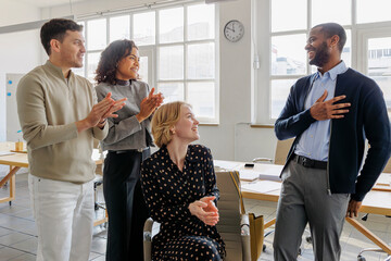 Formal business team clapping and celebrating success in office