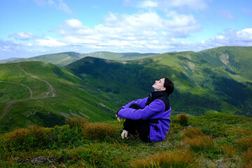 Girl resting on green moss with mountain view