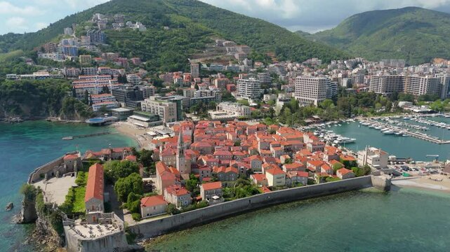 Aerial droen view Budva old town Stari harbour yachts Medieval Dubrovnik blue waters riviera mountains vacation holiday coastal Adriatic Mediterranean 
