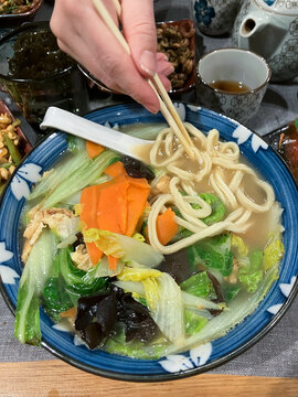 Eating lamian (traditional chinese noodles) from bowl with chopsticks