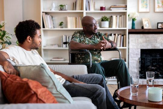 Man in wheelchair sitting by young son