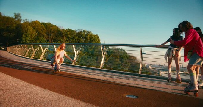 Multicultural Women in Casual Clothes Riding Roller Skates. Fit Beautiful Friends Moving and Spinning Around while Entertaining during Sunrise. Fitness Youth Culture Diversity