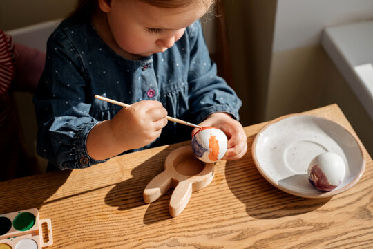 Siblings are painting Easter eggs.
