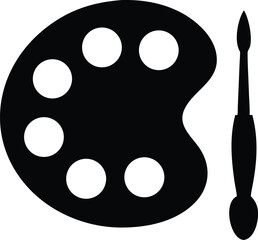 Fototapeta premium A black paint palette with six wells sits beside a matching brush