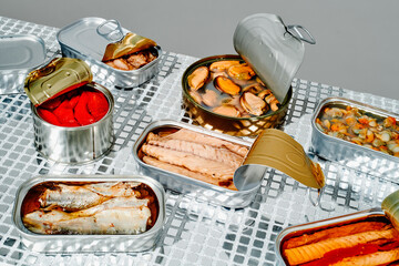 some open cans of tinned food on a mirrored surface