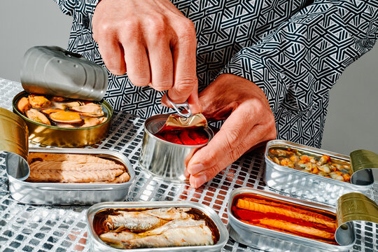man opening a can of roasted red bell peppers