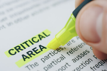 Critical area highlighted with yellow marker on paper for mechanical consulting focus and attention in business and technical work