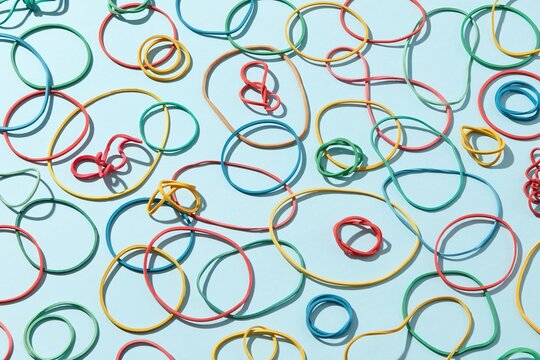 Multicoloured rubber bands lying on blue background