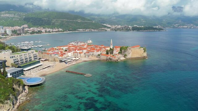 Aerial droen view Budva old town Stari harbour yachts Medieval Dubrovnik blue waters riviera mountains vacation holiday coastal Adriatic Mediterranean 